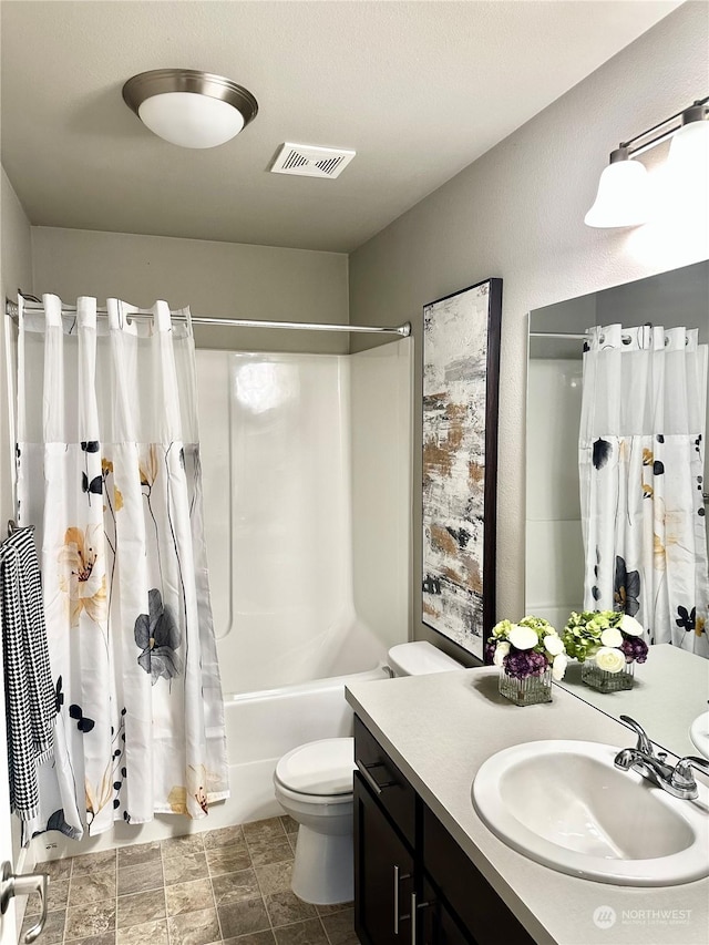 full bathroom with shower / tub combo with curtain, vanity, and toilet