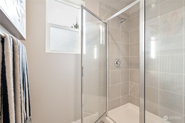 bathroom with a shower with door