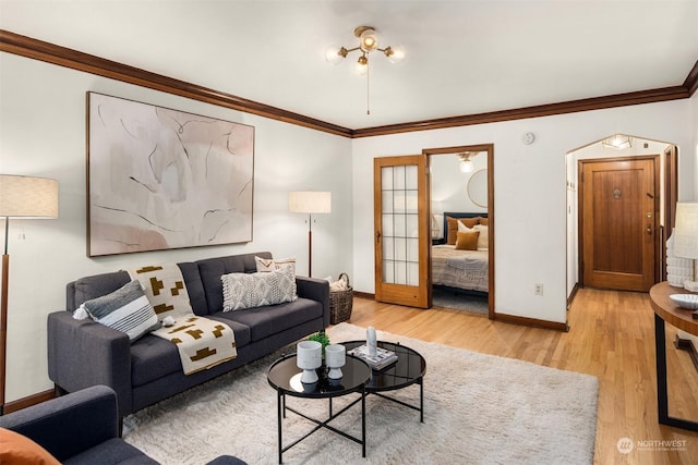 living room with light hardwood / wood-style floors, ornamental molding, and french doors