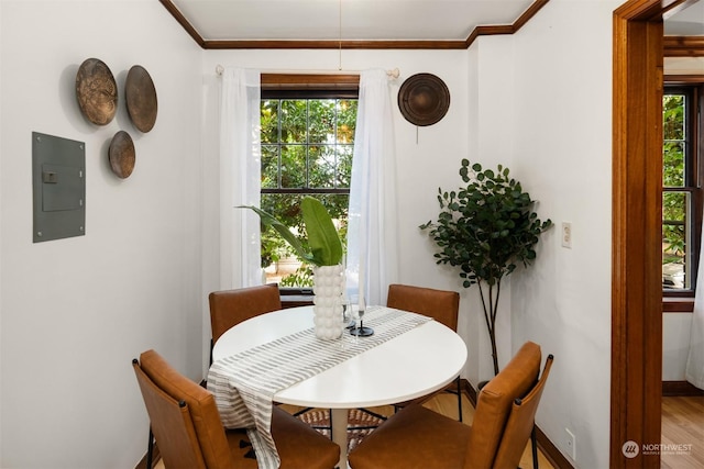 dining space featuring electric panel, hardwood / wood-style floors, and ornamental molding