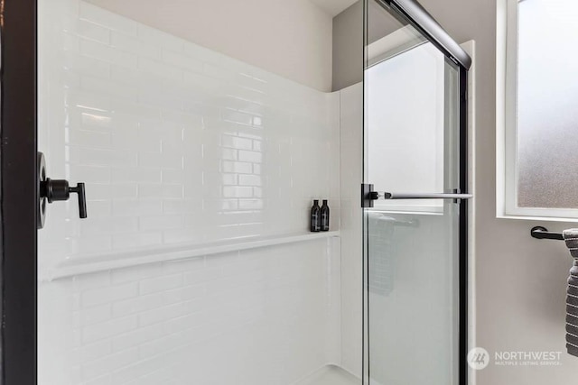 bathroom featuring a shower with door