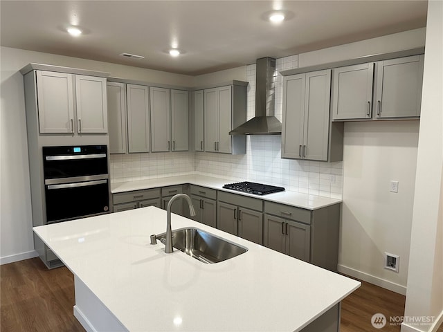 13628 187th St E Unit 36, Puyallup, WA 98374 - kitchen with gray cabinetry, a sink, wall chimney range hood, stainless steel gas stovetop, and baseboards
