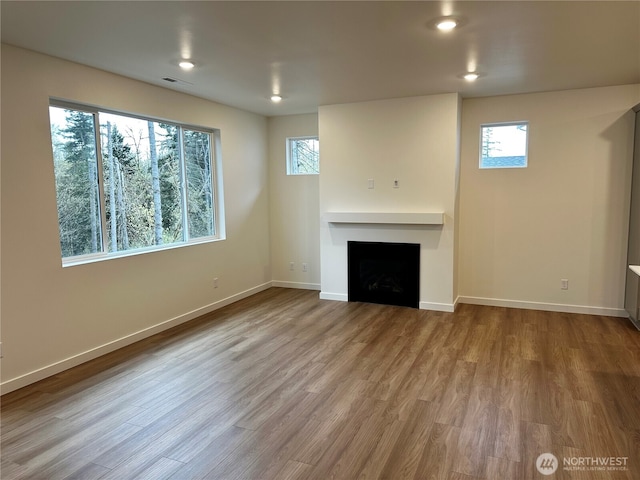 13628 187th St E Unit 36, Puyallup, WA 98374 - unfurnished living room featuring plenty of natural light, baseboards, a fireplace, wood finished floors, and recessed lighting