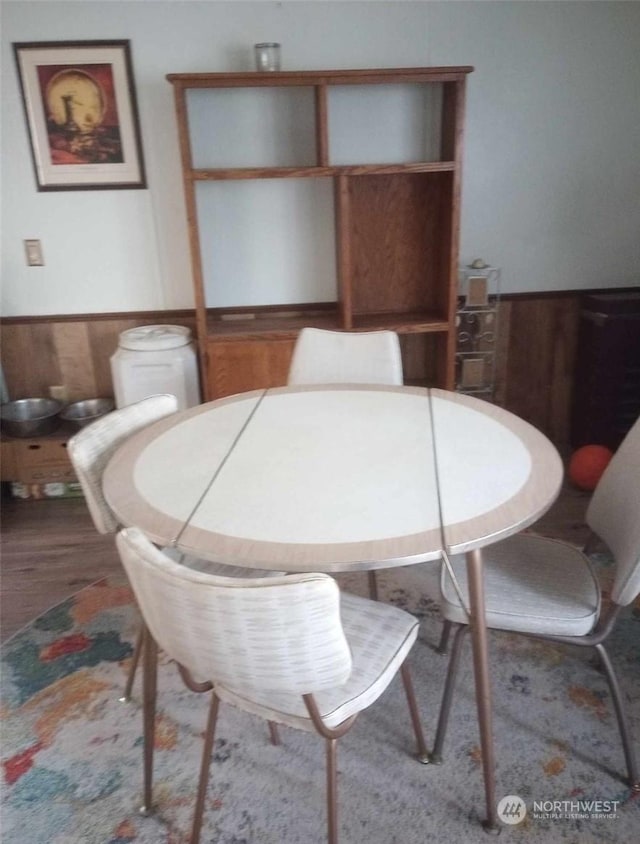 dining room featuring wooden walls and wood-type flooring