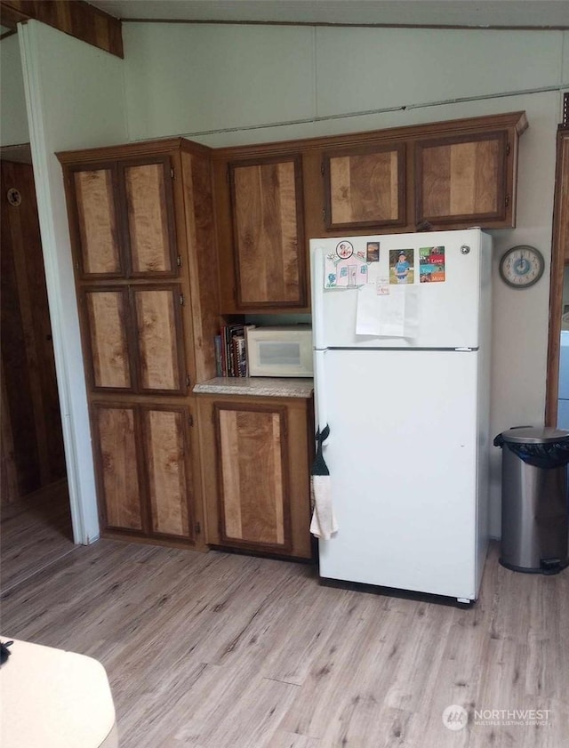 kitchen featuring light wood-type flooring and white appliances