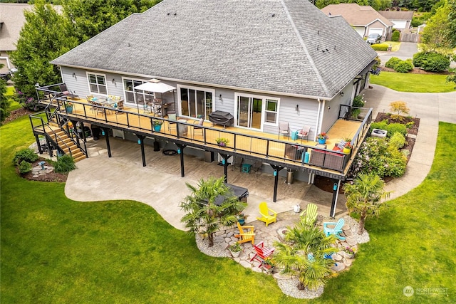 rear view of house featuring a patio, a lawn, and a wooden deck