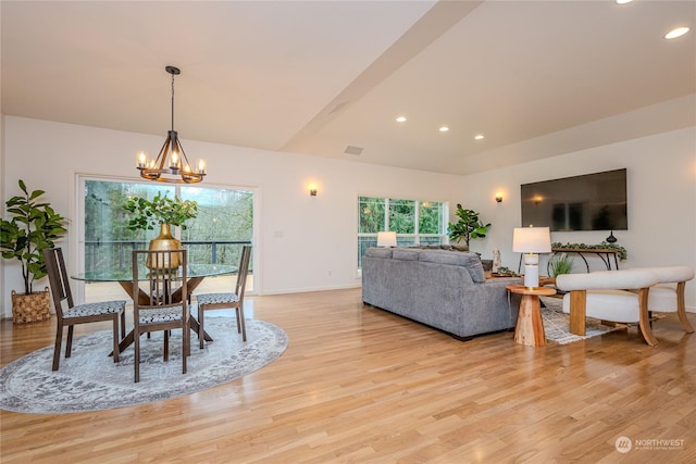 dining area with light hardwood / wood-style flooring and an inviting chandelier