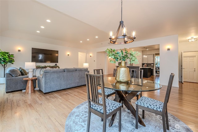 dining space with light hardwood / wood-style floors and a chandelier