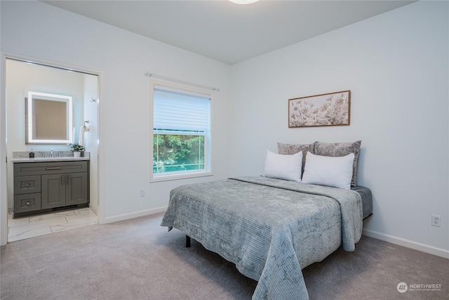 carpeted bedroom with sink and ensuite bath