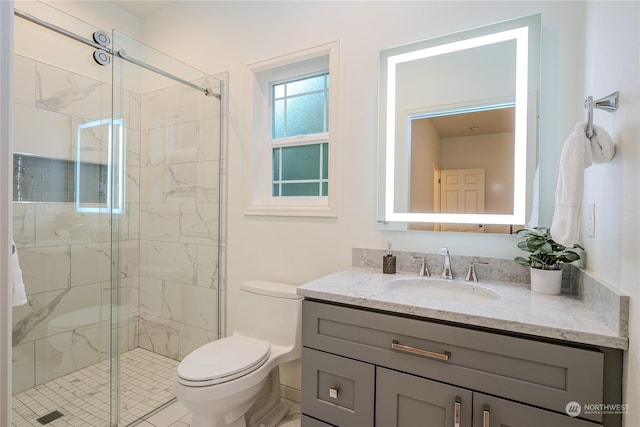 bathroom featuring a shower with shower door, vanity, and toilet