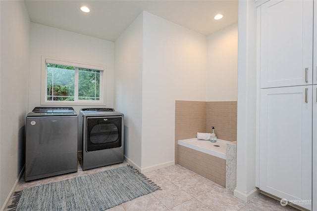 laundry room with washer and dryer and light tile patterned flooring