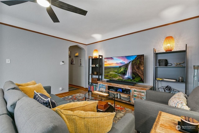 living room featuring ceiling fan, crown molding, and wood-type flooring