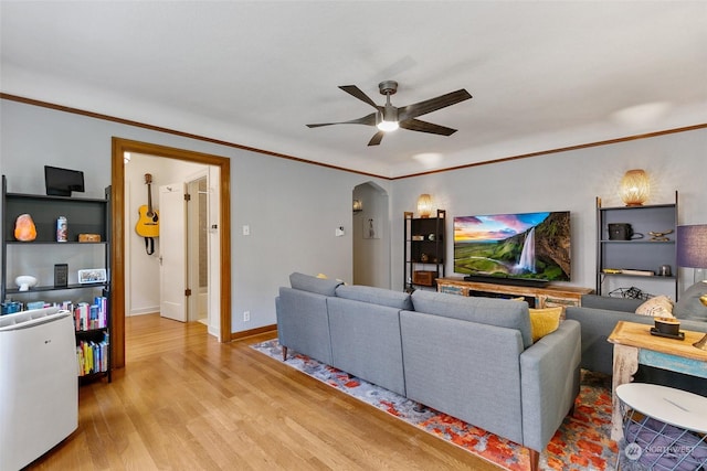 living room featuring light hardwood / wood-style floors, ceiling fan, and crown molding