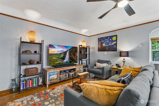 living room with ceiling fan, wood-type flooring, and ornamental molding