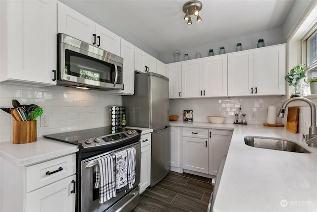 kitchen with tasteful backsplash, white cabinetry, sink, and appliances with stainless steel finishes