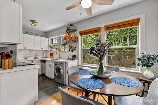 kitchen featuring white cabinets, stainless steel dishwasher, sink, and washer / clothes dryer