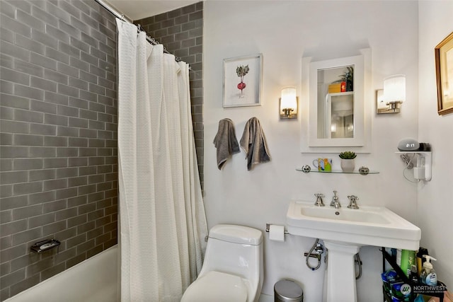 full bathroom with sink, shower / bath combo with shower curtain, and toilet