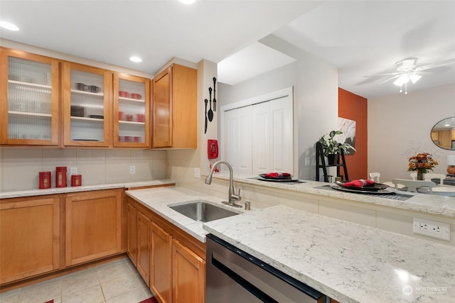 kitchen featuring ceiling fan, sink, stainless steel dishwasher, backsplash, and light tile patterned floors