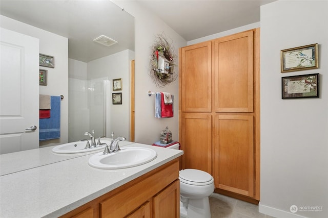 bathroom with tile patterned flooring, vanity, and toilet