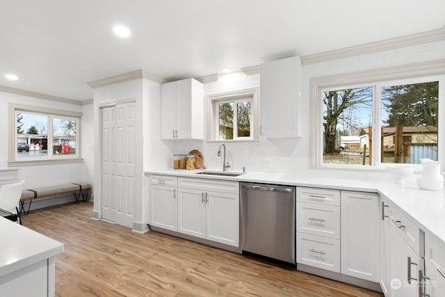 kitchen with white cabinetry, dishwasher, light hardwood / wood-style floors, and sink