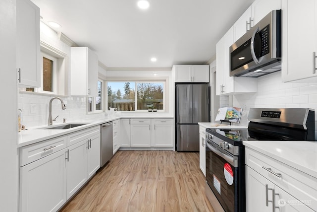 kitchen featuring white cabinets, backsplash, stainless steel appliances, and sink