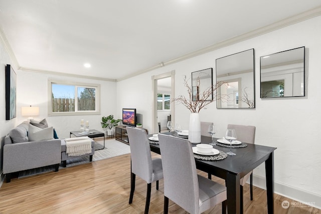 dining space with plenty of natural light, light wood-type flooring, and crown molding