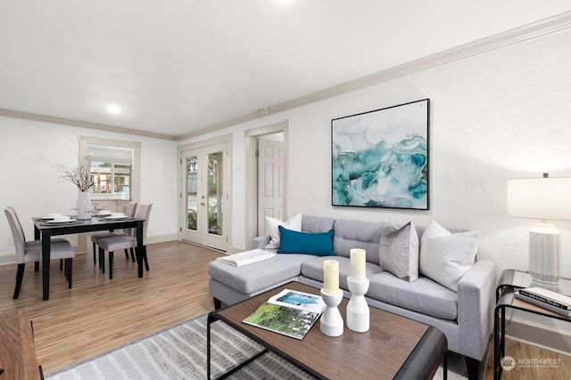 living room with hardwood / wood-style flooring, ornamental molding, and french doors