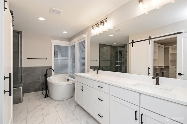 bathroom with separate shower and tub, vanity, and tile walls