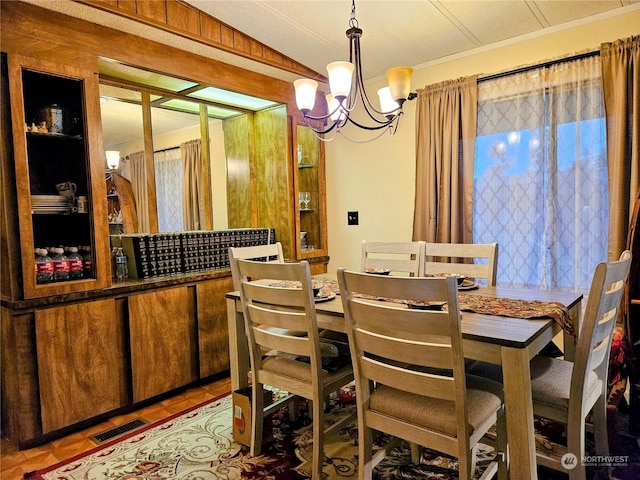 dining area with tile patterned flooring, vaulted ceiling, and an inviting chandelier