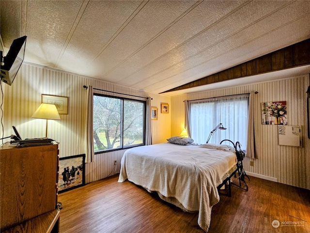 bedroom featuring wood-type flooring, a textured ceiling, and vaulted ceiling