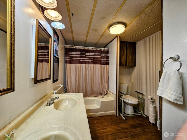 full bathroom with shower / bath combo, hardwood / wood-style floors, a textured ceiling, toilet, and vanity