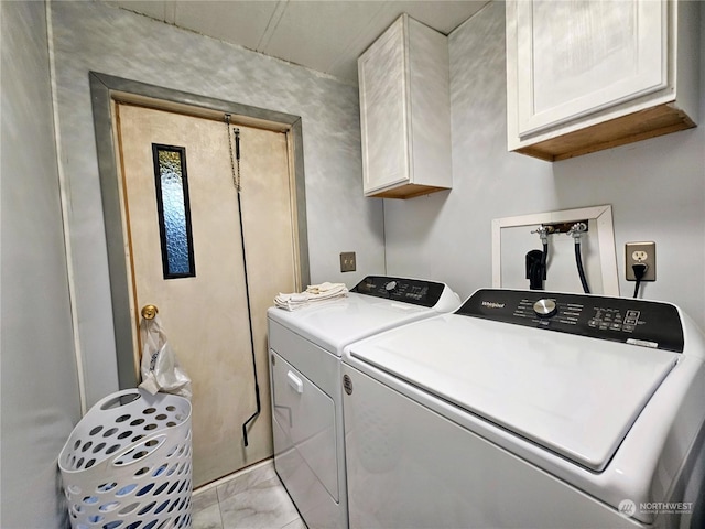 washroom featuring washer and clothes dryer and cabinets