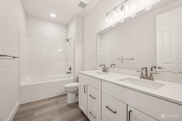 full bathroom with vanity, hardwood / wood-style flooring, toilet, and shower / washtub combination