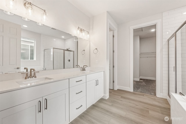 bathroom featuring vanity, wood-type flooring, and a shower with shower door