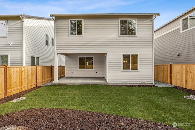 rear view of house featuring a lawn and a patio area