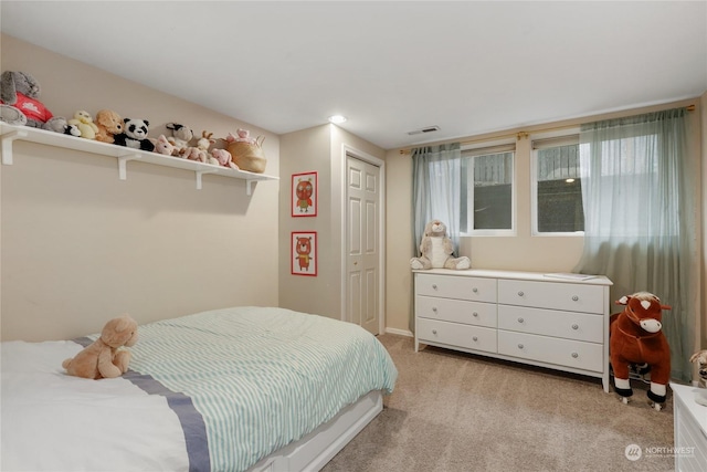 bedroom with light carpet and a closet