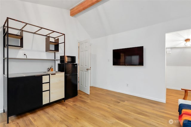 kitchen featuring sink, black appliances, light hardwood / wood-style flooring, and vaulted ceiling with beams