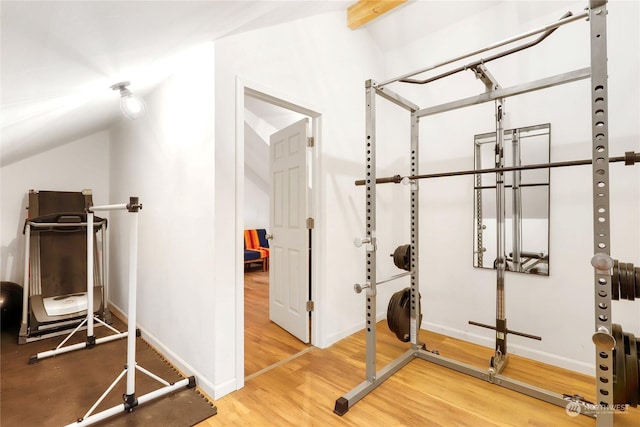 exercise room featuring hardwood / wood-style flooring and lofted ceiling