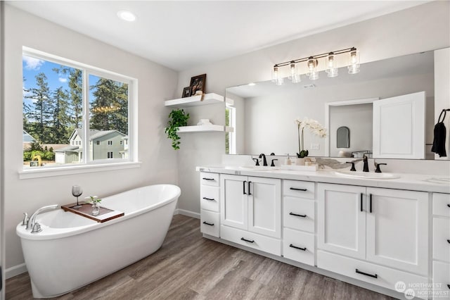 bathroom featuring vanity, a bath, and hardwood / wood-style flooring