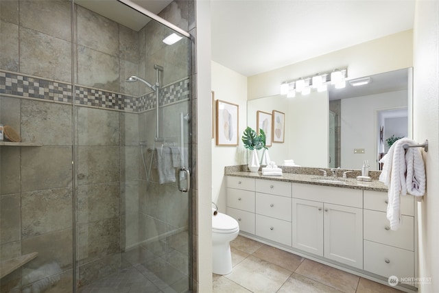 bathroom featuring vanity, an enclosed shower, tile patterned floors, and toilet