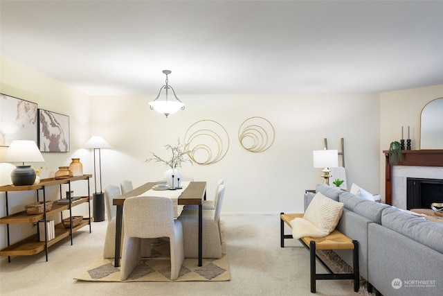 dining area featuring a premium fireplace and light carpet