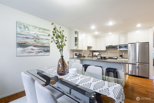 dining room with sink and light wood-type flooring