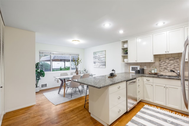 kitchen with white cabinets, kitchen peninsula, dishwasher, and stone counters