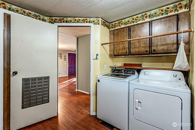 washroom with cabinets, dark hardwood / wood-style flooring, a textured ceiling, and washing machine and clothes dryer