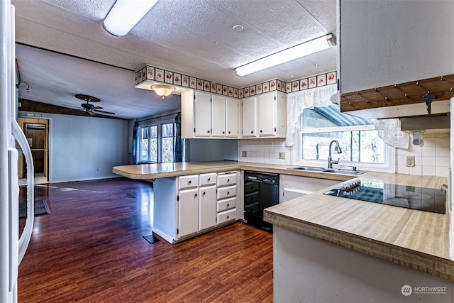 kitchen with kitchen peninsula, white cabinets, ceiling fan, and black appliances