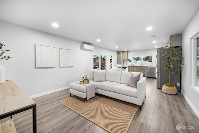 living room with light hardwood / wood-style floors and a wall mounted AC