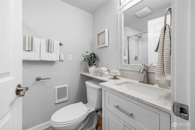 bathroom featuring vanity, heating unit, toilet, and walk in shower