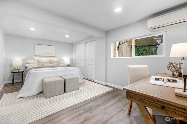 bedroom featuring hardwood / wood-style flooring, a wall unit AC, and a closet