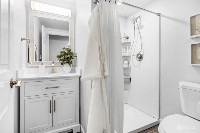 bathroom featuring vanity, toilet, and a shower