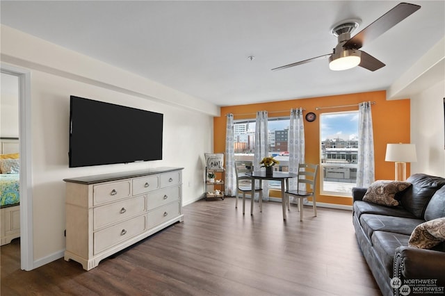 living room featuring ceiling fan and dark hardwood / wood-style floors